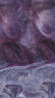 Dikey video. Odaklanamayan parlak emülsiyon. Prizma sıvısı. Renkli, parıldayan, sıvı sızıntısı desenli soyut bir arka plan. Mor gri boya karışımı.