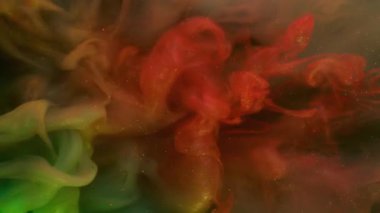 Mürekkep karışımı. Parıltı sıçraması. Odaklanmamış turuncu mavi renkli su tanecikleri soyut arkaplanda yayılan akrilik gökkuşağı bulutu.