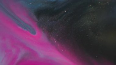 Parıldayan mürekkep. Renk sıvısı akıyor. Odaklanmamış pembe mavi su dokusu soyut sanat arka planında yüzen koyu siyah lekeler..