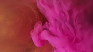 Mürekkep fırıldağı. Arkaplanı boya. Odaklanmamış pembe turuncu altın rengi duman parlatıcısı yaratıcı sanat soyutlamasına sıçrıyor..