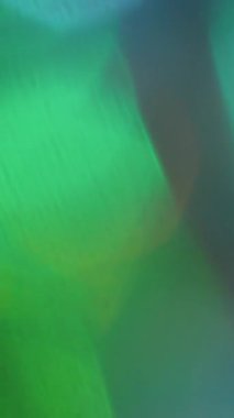 Dikey video. Odaklanamayan parıltı. Bokeh ışığı. Renkli aydınlatma analog optik etkisi. Cyan yeşil parlak eğimli soyut güneş ışını soyut arkaplan.