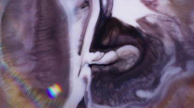 Dalgacık parlak mürekkep. Görüntü pırıl pırıl akıyor. Soyut koyu arkaplan üzerinde yüzen mavi beyaz yeşil renkli gökkuşağı sıvısı.