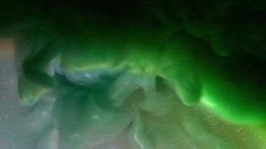 Mürekkep karışımı. Renkli bulut dokusu. Odaklanmamış mavi mor sıçrama gökkuşağı simli su soyut koyu siyah arka planda yayılıyor..