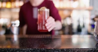 Kokteyl servisi. Ferahlatıcı içecek hazırlanıyor. Barmen tezgahın üzerine buz küpleri ve kurutulmuş nane şekeri koyuyor..