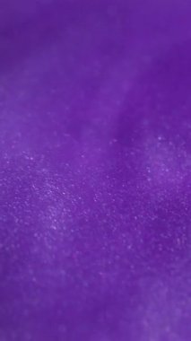 Dikey video. Işıl ışıl. Mistik sıvı. Toz bulutu mürekkep emülsiyonu. Mor mor renk parlak desen soyut bulanık scintilla arkaplan.