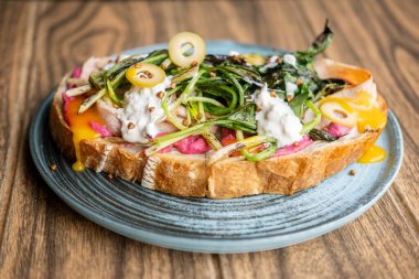 Kahvaltı servis edildi. Lezzetli bruschetta. Sağlıklı vejetaryen tostu ve pancar otları. Ekmeğin üstünde ızgara yeşillikle sulu kremalı sos..