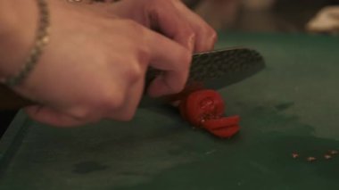 Sağlıklı yemek yapmak. Sebze dilimliyorum. Eller taze doğal malzemeleri kesiyor. Şef kasede salatalık ve vejetaryen salatası tartıyor..