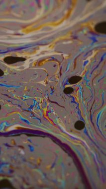 Dikey video. Yağ sıvısı. Mürekkep karışımı. Odaklanamayan mavi yeşil renk akan mor pembe sıçrama soyut koyu siyah sanat arka planında yüzüyor..