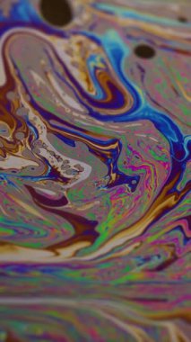 Dikey video. Yanardöner dalga. Kabarcık dokusu. Bulanık mavi pembe pembe renkli benzin pigmenti mor soyut arkaplanda yüzüyor..