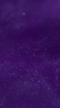 Dikey video. Islak bir parıltı. Cazibeli boya dalgası. Mor akış rotasyonu soyut arka plan. Sanat odaksız girdap yıldızlı gece galaksisi akışı.