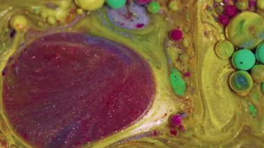 Parlak bir serpinti. Mürekkep yağı karışımı. Odaklanmamış sarı, kırmızı, ışıl ışıl su dokusu. Süzülen parlak baloncuklar, soyut sanat arkaplanı..