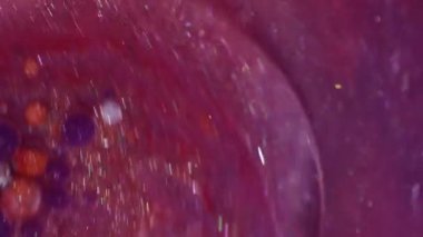 Parıldayan sıvı. Mürekkep döküldü. Odaklanmamış pembe turuncu renkli parlak yağ, soyut yaratıcı arka planda yüzen beyaz su..