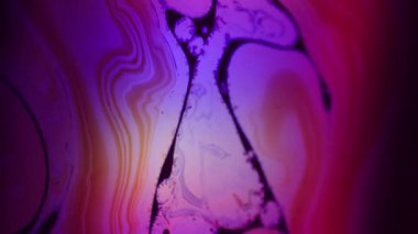 Mürekkep karışımı çözüldü. Neon akışı. Siyah suyun üzerinde mor menekşe kırmızısı sıvı girdap. Soyut parlak renk girdap arkaplanı.