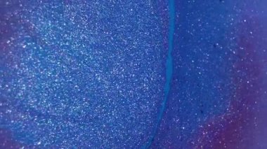 Canlı boya sıvısı. Mavi akış. Soyut yaratıcı akrilik sanat arka planında sönük mor renkli sim damlası yüzüyor.