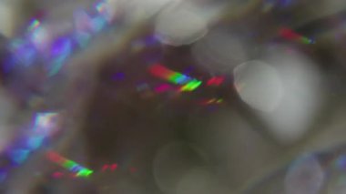 Crystal lens blur. Reflection flash texture. Red green blue color flare swirl on dark gray background. Abstract kaleidoscope effect.