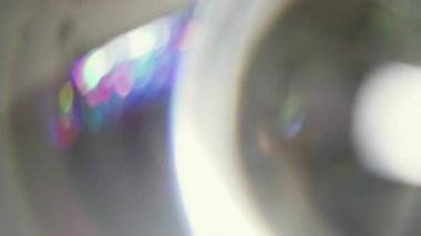 Odaklanmamış lens parlıyor. Yuvarlak parıltı. Beyaz mor ışık çemberi gri soyut arkaplanda döner. Parlak gradyan renk flaş bulanık tünel ışını.