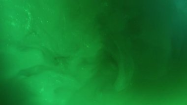Pigment sıçraması. Boya girdabı. Yeşil mürekkep parıldayan ışın patlaması sisi karıştırıcı sanat sıvısı. Odaklanmamış renk soyut simli akış arkaplanı.
