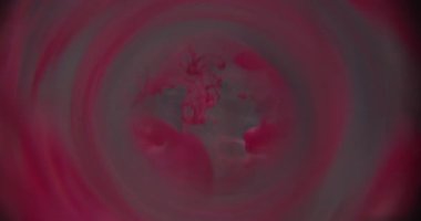 Duman mürekkebi bulanıklığı. Tünel merceği. Sıvı içinde dönen kırmızı pembe boya dumanı. Soyut gri arkaplanda yuvarlak prizmaya renk damlası döküldü.