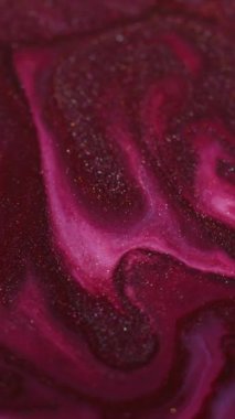 Dikey video. Parlak boya dökülmüş. Parıldayan sıvı dalga. Odaklanmamış pembe renk parıldayan akrilik doku akışı soyut sanat arkaplanı.