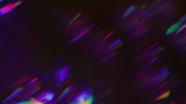 Odaklanmamış kaleydoskop parıltısı. Işın prizması. Soyut siyah arkaplanda gökkuşağı renkleri parıldıyor. Neon mor yeşil kırılma lensi.