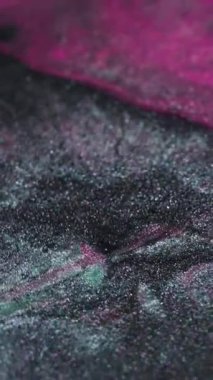 Dikey video. Işıldayan su sıçraması. Parıltılı boya döküldü. Odaklanmamış pembe renk parlak damlalar desen sıvı karışım akışı soyut sanat arka planı.