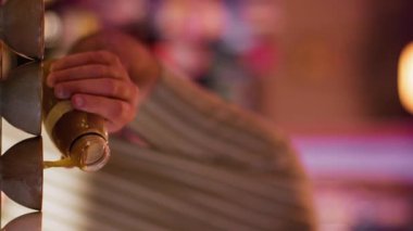 Dikey video. Barmen sıvı dolduruyor. Asya barı. Erkek barmen sake için küçük seramik bardakları porsiyonize etti. Geleneksel Japon alkolik siparişi veren adam..