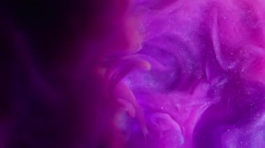 Işıl ışıl dökülüyor. Mürekkep girdabı. Pembe mor parlak akış siyah arkaplanda karışıyor. Odaklanamayan parlak gökkuşağı renginde ışık kemeri etrafında soyut su.