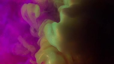 Renkli duman. Boya patlaması. Siyah arkaplanda mor turuncu parlak toz girdap lekesi. Soyut parlayan su dokusu.