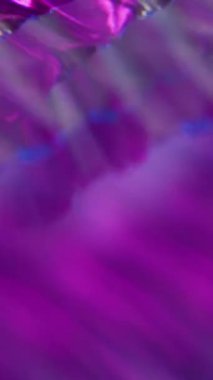 Dikey video. Bulanık işaret fişeği. Parlak arka plan. Odaklanmamış mor neon renkli optik parıltı aydınlatmalı doku sanatın görsel soyutlaması üzerinde parıldıyor.