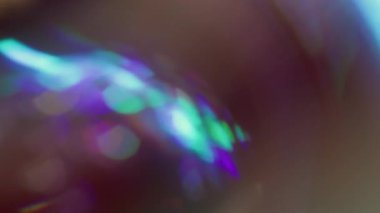 Odaklanamayan holografik ışıltı. Kaçak aydınlatma. Neon renkli küre siyaha yansıyan kaleydoskop dönüşü. Mor mavi soyut bulanık arkaplan.