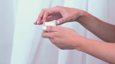 El estetiği terapisi. Krema kavanozu. Beyaz arka planda kadın merhem kutusu açılıyor. Kadın günlük nemlendirici ürün uyguluyor..