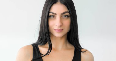 Yüz güzelliği. Sağlıklı saçlar. Yumuşak ciltli, barışçıl bir yüzü olan hassas genç bir kadın. Kadın yüz cazibesi kozmetikleri beyaza izole edilmiş..