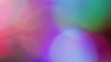 Gökkuşağı parıltısı bulanıklığı. Renkli sızıntı. Mor kırmızı, çözünmüş yeşil halkalar koyu siyah arka planda akar. Spektrum canlı yansıma soyut doku.