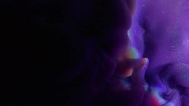 Mistik boya. Parıltı spreyi. Mor menekşe duman tozu mürekkebi siyah soyut arkaplanda dökülmüş. Odaklanmış su, parlak gökkuşağı lensi, parlak renk sıçraması..