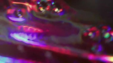 Holografik ışık dağıldı. Ray sızıntısı. Renkli neon, pürüzlü dokuma, siyah arkaplan üzerindeki soyut ışıltıyla aydınlatılmış..