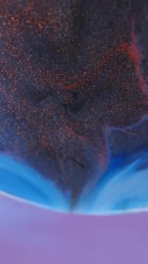 Dikey video. Mürekkep döküldü. Köpüklü boya karışımı. Bulanık mavi bronz renk dokusu soyut neon arkaplanda parlak kabarcık parçacıkları akışı.