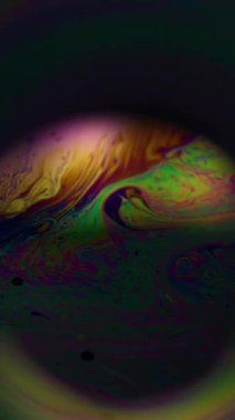 Dikey video. Mistik çözülmüş akış. Boya karışımı. Bokeh yuvarlak lens efekti renkli tünel iskeleti. Siyah evrende fantezi küresi arkaplan örtüsü.