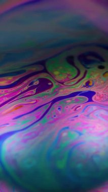 Dikey video. Bulanık gökkuşağı yağı. Boya karışımı. Çoklu renkli mercek dalgası benzinli neon pigmenti arka planı. Soyut benzin mor çerçeve sıvısı.