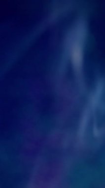 Dikey video. Soyut sis. Sis mürekkebi. Odaksız mavi neon renkli su dumanı akrilik buhar pigmenti koyu siyah sanat arka planına yayılıyor..