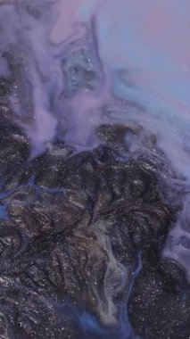 Dikey video. Boya dökülüyor. Renk sıvısı. Odaklanmamış pembe dalga köpüren su akışı soyut sanat arka planında yüzen koyu siyah leke dokusu.