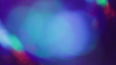 Odaklanmamış ışıltı dokusu. Işın prizması. Mor mavi kırmızı daireler karanlıkta parıldıyor. Neon renkli yansıtma lensi soyut sanat arkaplanı.