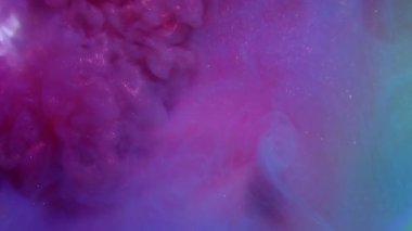 Parıldayan duman. Parlak mürekkep. Mor menekşe parlak sıvı neon renk efekti siyah su arka planında. Odaklanamayan soyut lens.