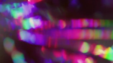 Prizma geçmişi bulanık. Yansıma flaş dokusu. Siyah üzerinde kırmızı yeşil parlak renk girdabı. Soyut kaleydoskop optik etkisi.