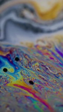 Dikey video. Odaklanmamış boya karışımı. Sabun renkli kaos. Canlı dalgalı kıvrım sıvısı. Fantezi gradyan kontrastı karışık benzin yüzen soyut arkaplan.