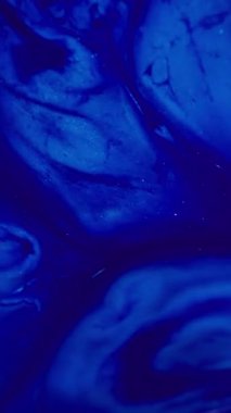 Dikey video. Mavi dalga. Sıvı doku. Odaklanamayan parlak renkli su parçacıkları soyut akrilik yaratıcı arka planda yayılıyor.