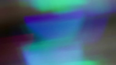 Gökkuşağı parıltısı bulanıklığı. Renkli sızıntı. Mor kırmızı, çözünmüş yeşil halkalar koyu siyah arka planda akar. Spektrum canlı yansıma soyut doku.