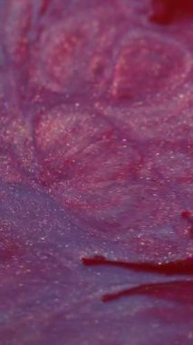 Dikey video. Parlak mürekkep karışımı. Parlak sıvı sıçraması. Odaklanmamış pembe renk parçacıkları dokusu akrilik emülsiyon sızıntısı soyut sanat arka planı.