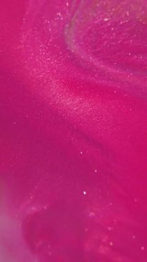 Dikey video. Görüntü mürekkep yayıyor. Pigment dokusu. Odaklanmamış pembe renk sıvı ışıl ışıl, soyut bokeh arkaplan üzerine akan emülsiyon..