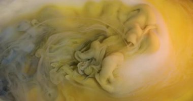 Mürekkep karışımı. Su altı sarı sıvısı. Odaklanamayan mavi beyaz bulutlu akrilik doku soyut ve canlı arkaplana sıcak su sıçratıyor..