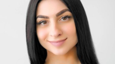 Sağlık portresi. Gülümseyen model. Uzun saçlı, güzel tenli genç bir kadın. Doğal cazibe, beyaz tenli genç güzellik..